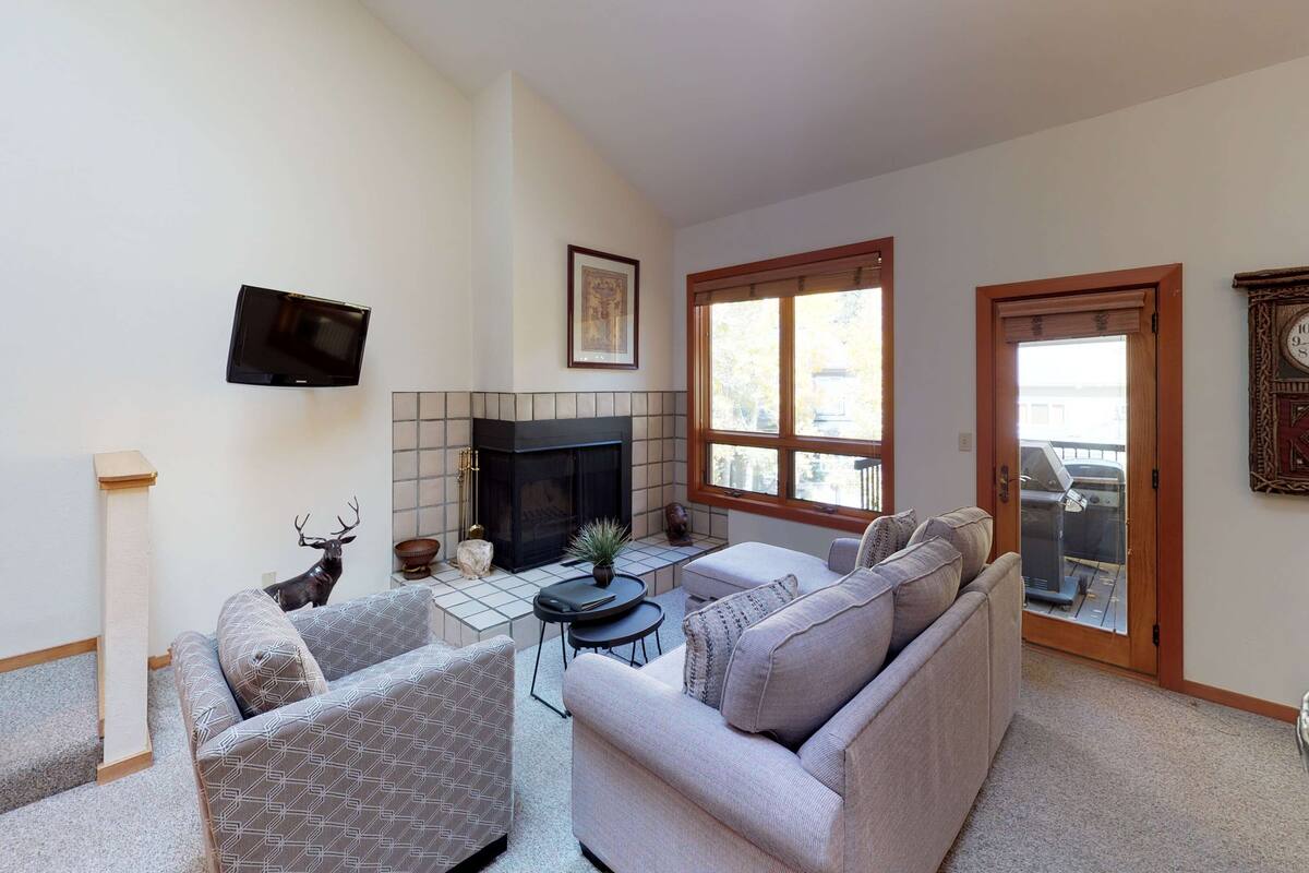A living room with a fireplace, a television, and a sofa.