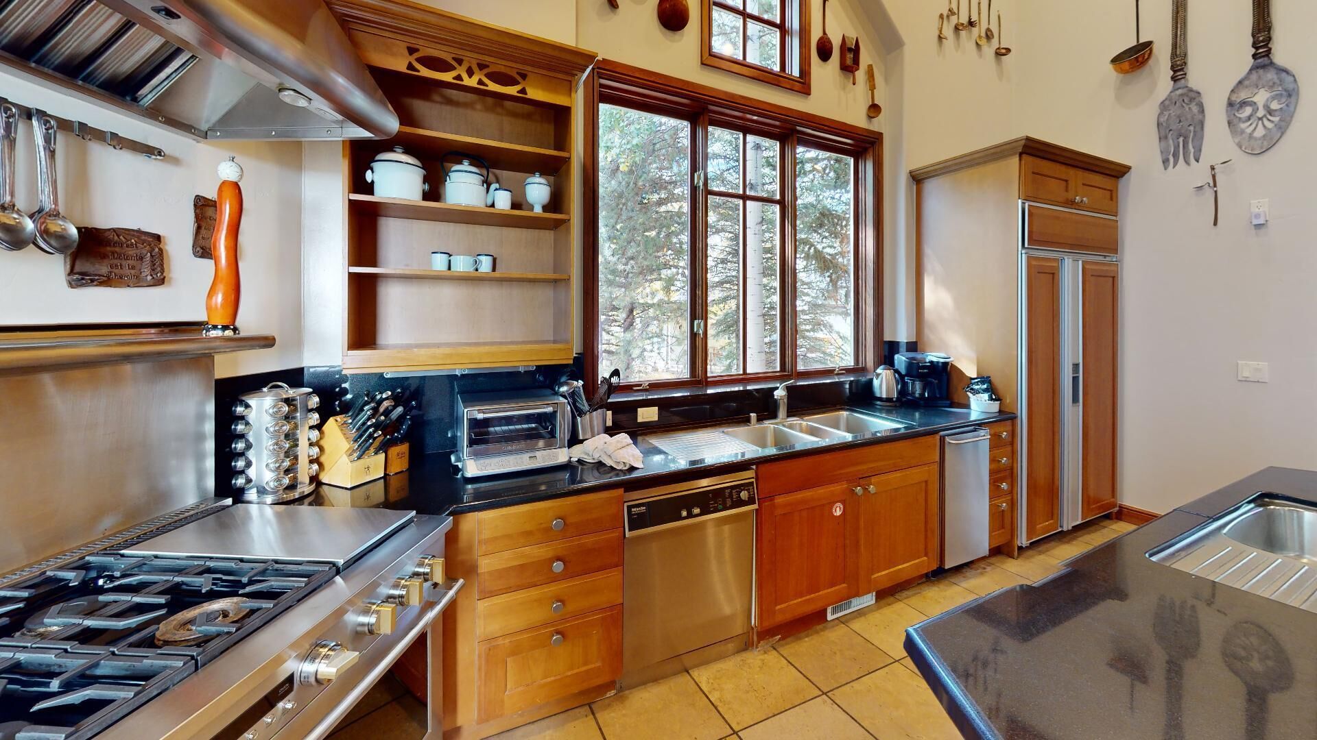 A modern kitchen with a gas stove, dishwasher, and wooden cabinets.