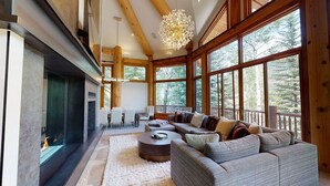 Un salón amplio con chimenea, ventanas grandes y una zona de estar acogedora.