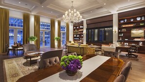 A spacious living room with a large wooden dining table, comfortable seating, a chandelier, and a bookshelf filled with decorative items. - InterContinental New York Barclay by IHG (New York)