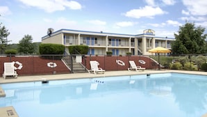A Days Inn with a swimming pool, lounge chairs, and a fenced area. - Days Inn by Wyndham Staunton (Staunton)