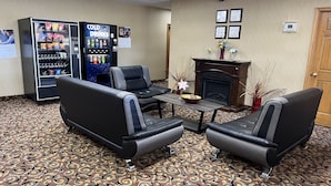 A hotel lobby with seating, vending machines, a fireplace, and patterned carpet. - Days Inn by Wyndham Staunton (Staunton)