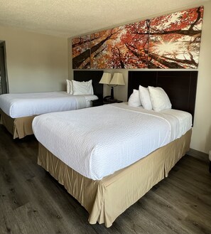 A hotel room with two single beds and a larger bed, all with white bedding. - Days Inn by Wyndham Staunton (Staunton)