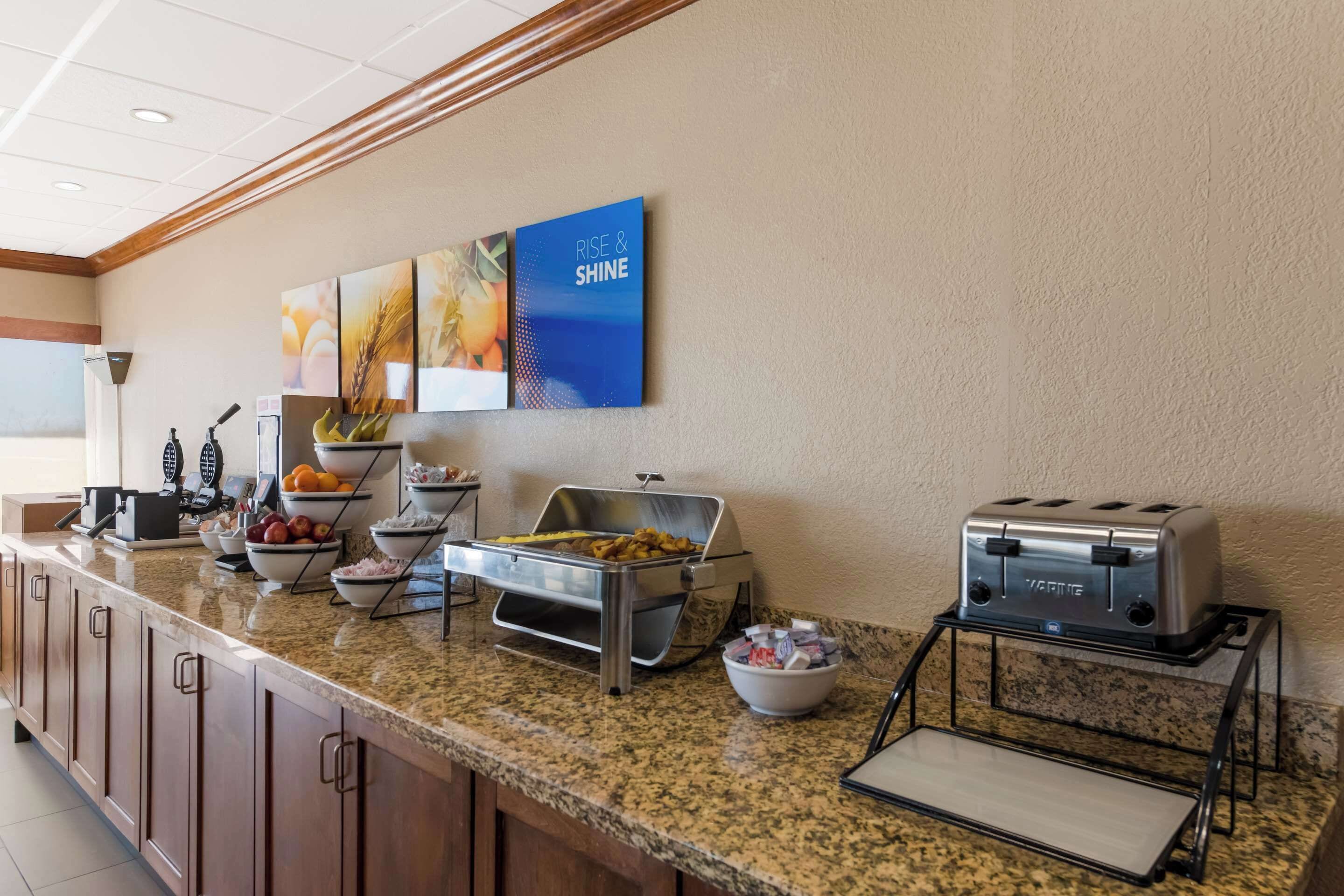 A buffet setup with various food items and a toaster.