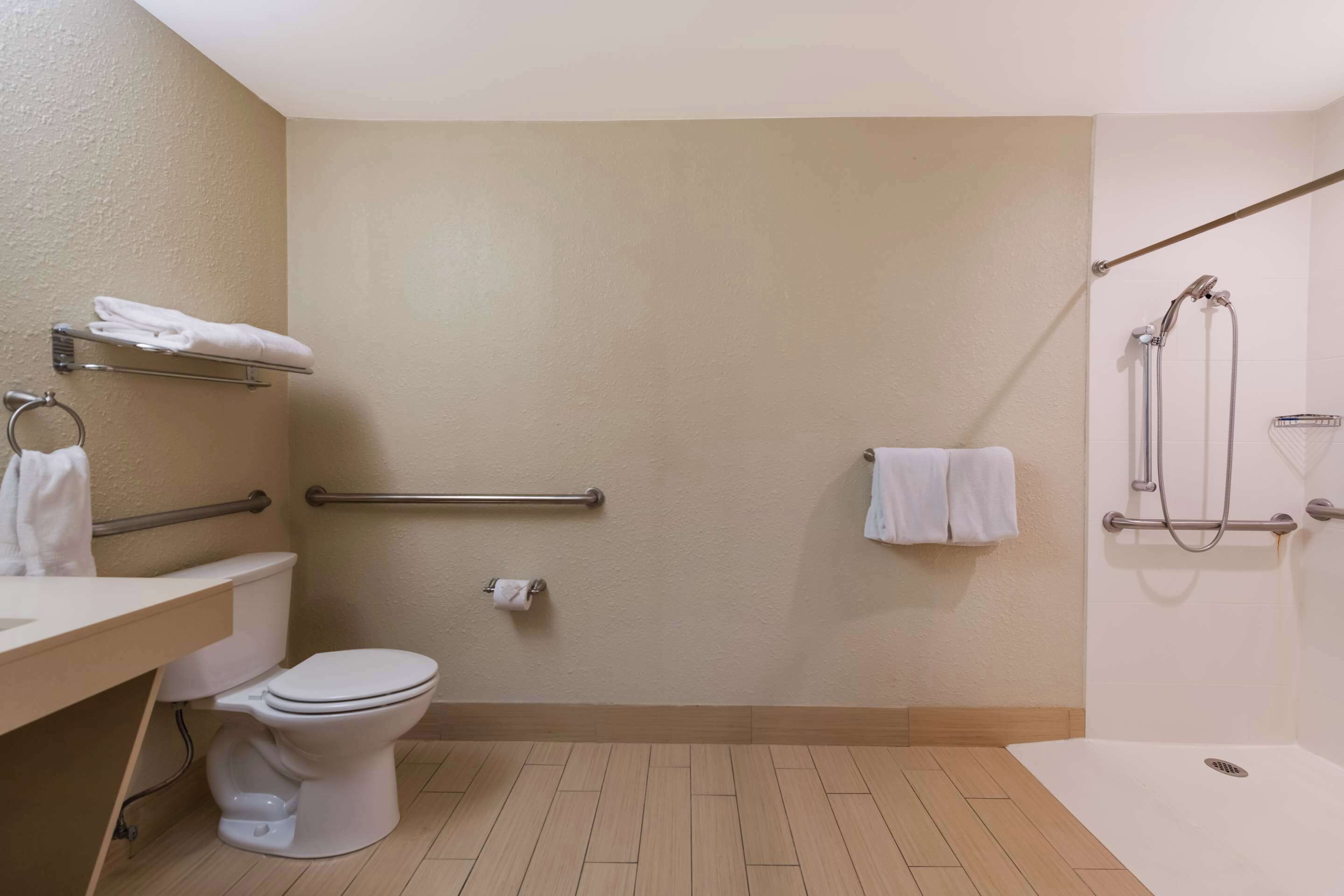 Une salle de bain comprenant des toilettes, un lavabo, une douche et un porte-serviettes.