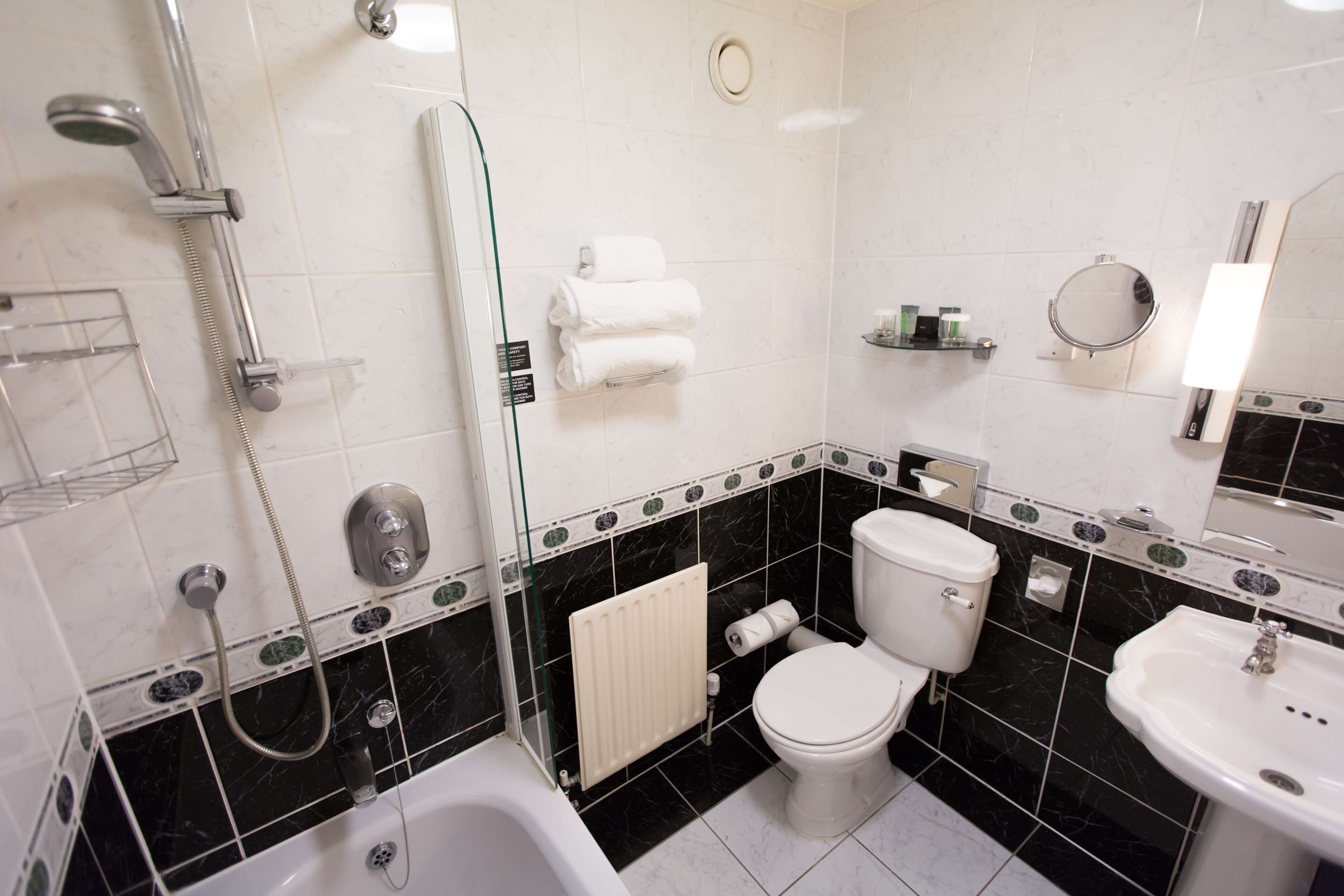 A bathroom with a bathtub, toilet, and sink.