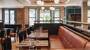 A restaurant with wooden walls, large windows, and a seating area with tables and chairs. - The Malone Hotel (Belfast)