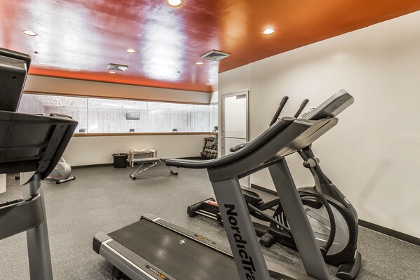 A gym with treadmills, a stationary bike, and a mirrored wall.
