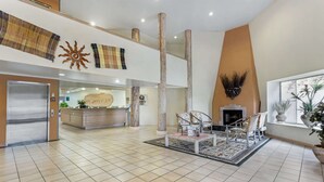 Un vestíbulo amplio con mostrador de recepción, zona de estar y chimenea.