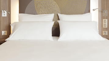 Una cama bien hecha con sábanas blancas, un cabecero moderno con un diseño geométrico y una lámpara de pared.
