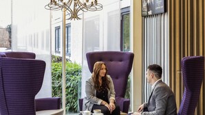 A modern indoor seating area with purple upholstered chairs and a chandelier. - Novotel Coventry M6/J3 (Coventry)