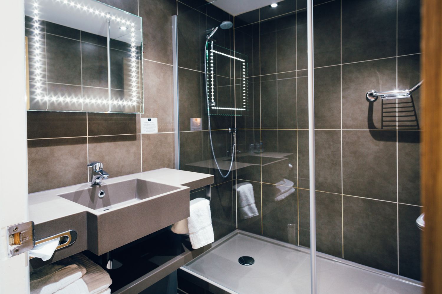Un baño moderno con tocador, espejo y ducha.