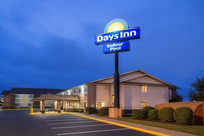 A Days Inn hotel with an indoor pool, a parking lot, and a building with a flat roof.