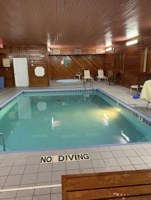 A pool with a 'NO DIVING' sign, wooden walls, and tiled flooring. - Days Inn by Wyndham Topeka (Topeka)