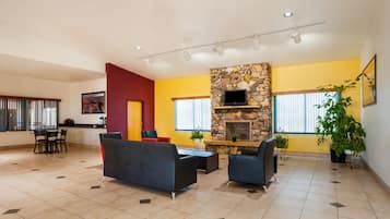 A spacious living area with a stone fireplace, comfortable seating, and large windows.