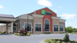 A Holiday Inn Express building with a brick facade, large windows, and a clear sky. - Holiday Inn Express Woodstock-Shenandoah Valley by IHG (Woodstock)