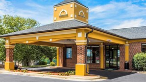 A yellow building with a covered entrance and a small tower-like structure. - Quality Inn Albemarle (Albemarle)