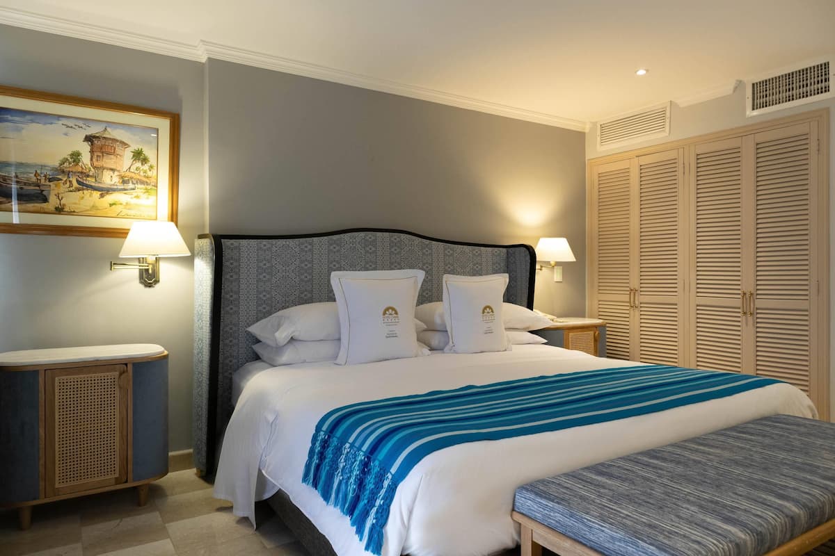 Een keurig opgemaakt slaapkamer met een bed, nachtkastjes en een kledingkast.
