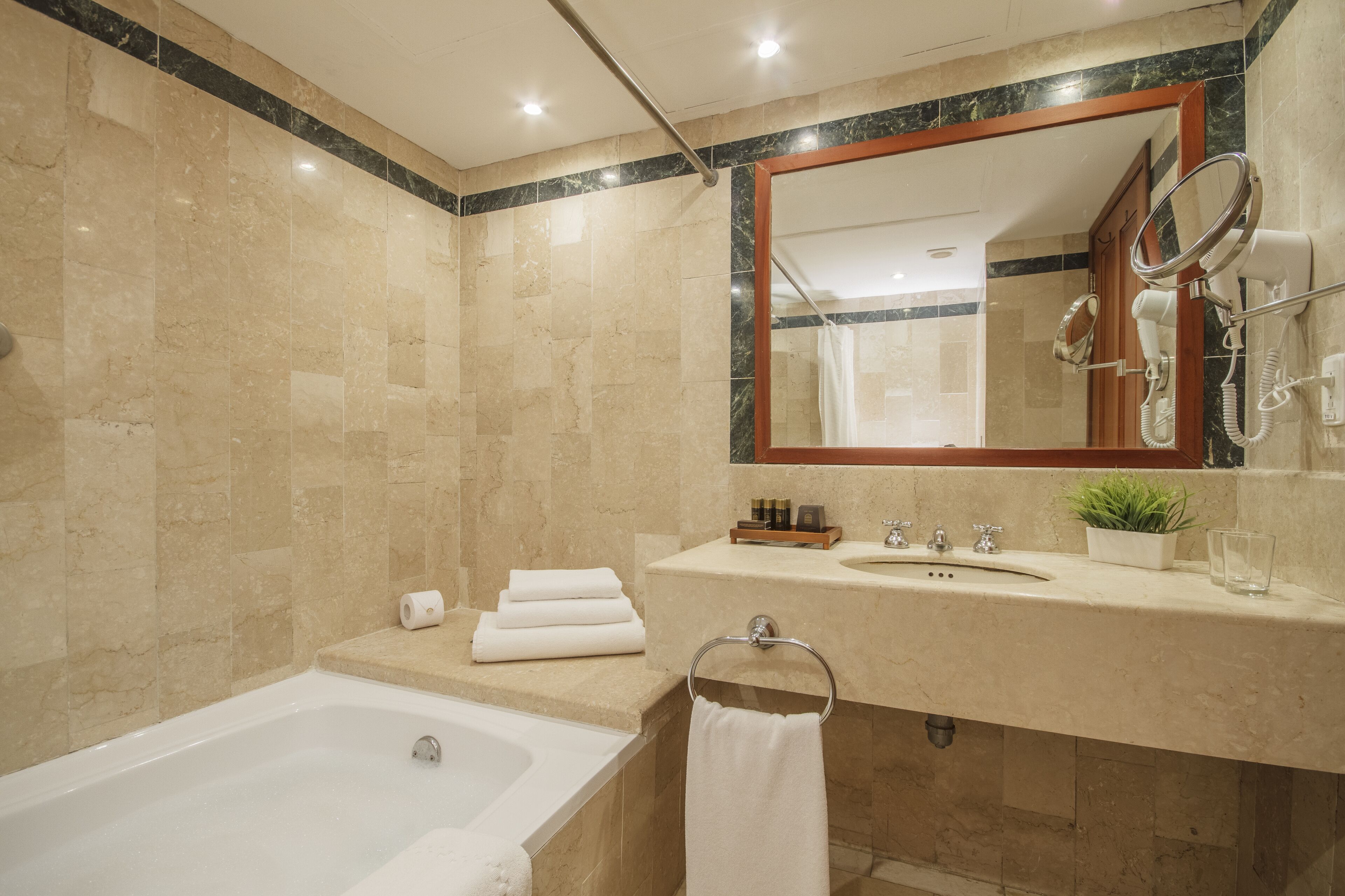 Une salle de bain moderne avec une baignoire, un meuble-lavabo avec un miroir et un espace douche.