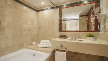 Une salle de bain moderne avec une baignoire, un meuble-lavabo avec un miroir et un espace douche.