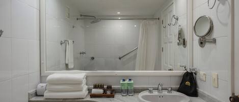 Un baño moderno con un espejo grande, un lavamanos y una zona de ducha.