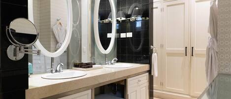 A modern bathroom with two sinks, a large mirror, and a vanity cabinet.