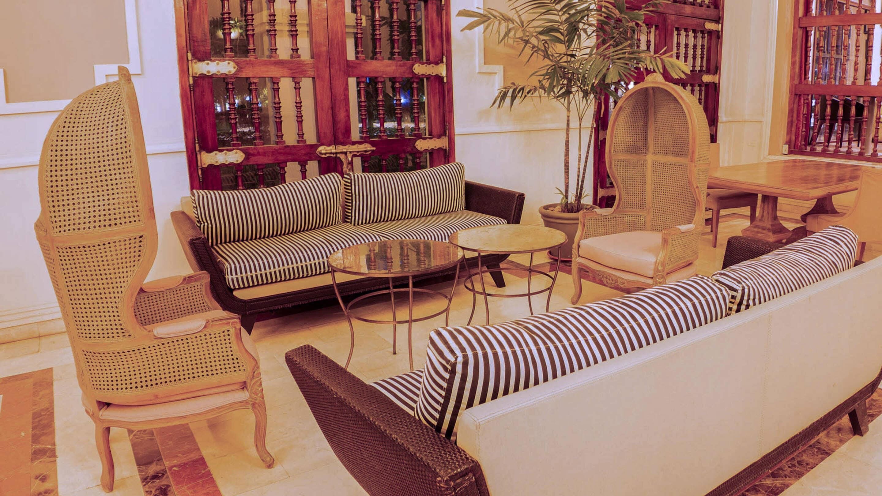A lounge area with a sofa, armchairs, a round coffee table, and a bookshelf.