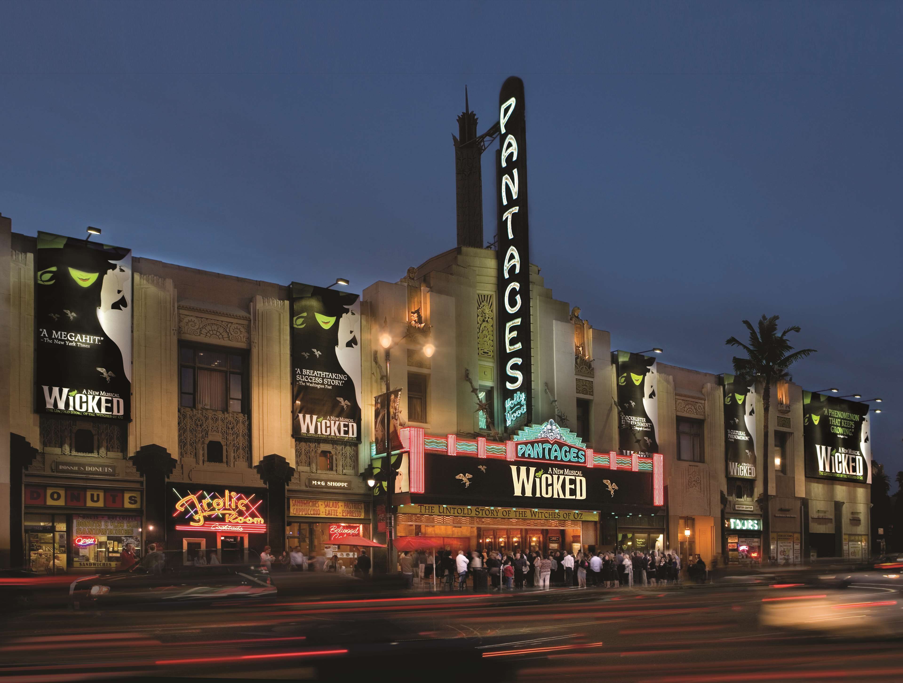 A theater with a marquee reading "Wicked" and "PANTAGES" on a busy street at night.