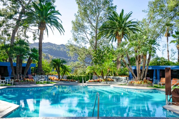 Una piscina al aire libre, una piscina climatizada, tumbonas