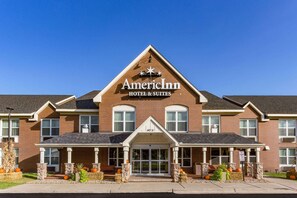 Een gebouw van baksteen met een bord waarop staat 'American Inn Hotel & Suites' en het cijfer '143 31' boven de ingang.