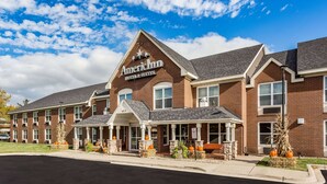 Un edificio de ladrillo con un cartel que dice "American Inn Hotel & Suites".