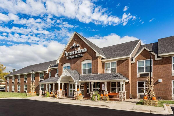 Een gebouw van baksteen met een bord waarop staat: American Inn Hotel & Suites.