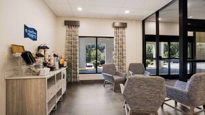 A reception area with a counter, chairs, and a view of the outside.