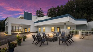 A modern hotel with a patio area featuring outdoor seating and a fire pit. - Clarion Pointe Sylva near Cherokee Area (Sylva)