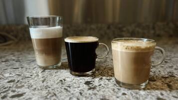 Three glasses of coffee on a textured countertop.