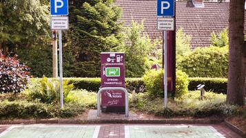 En parkeringsplads med ladestandere til elbiler og et skilt for NordWest Hotels.
