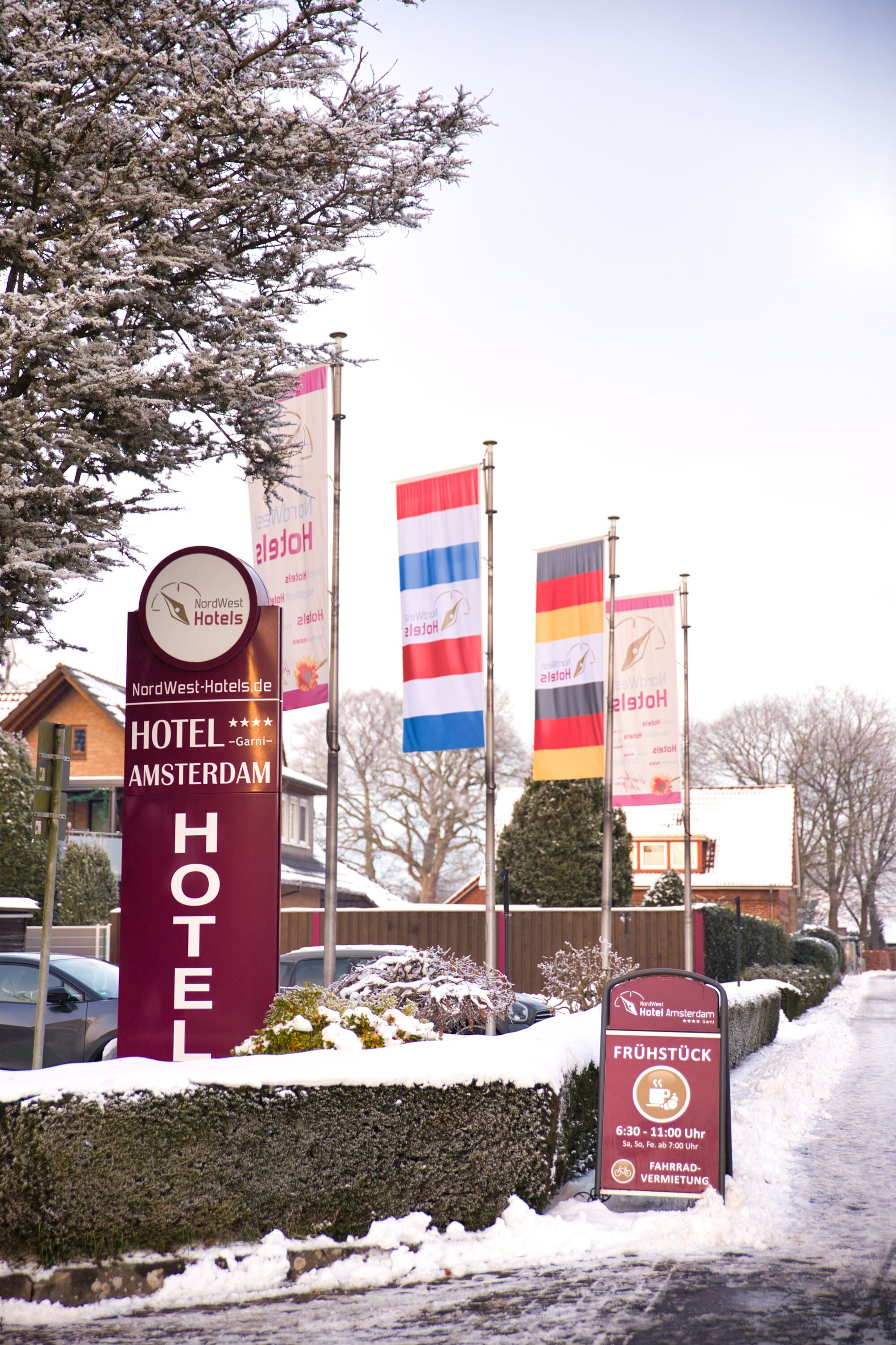 Et hotelskilt med 'HOTEL AMSTERDAM' og flag.