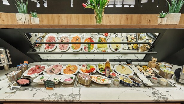 Un buffet proposant divers plats et une pancarte indiquant « Spécialités Kellogg et Fish ».