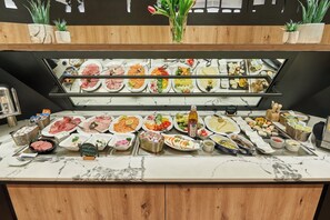 Een buffet met diverse gerechten en een bordje met de tekst 'Kellogg and Fish Specialties'.