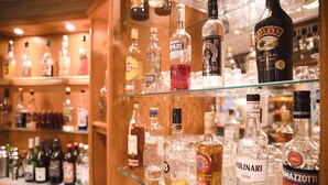 Un bar avec différentes bouteilles d’alcool exposées sur des étagères.