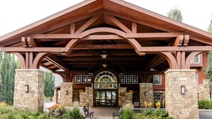 A lodge with a stone facade, wooden beams, and a covered entrance with benches. - The Wyoming Inn of Jackson Hole (Jackson)