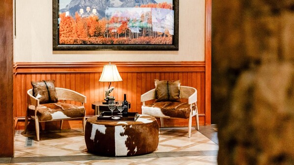 A lobby with two leather armchairs, a wooden coffee table, and a framed painting of autumn foliage on the wall. - The Wyoming Inn of Jackson Hole (Jackson)