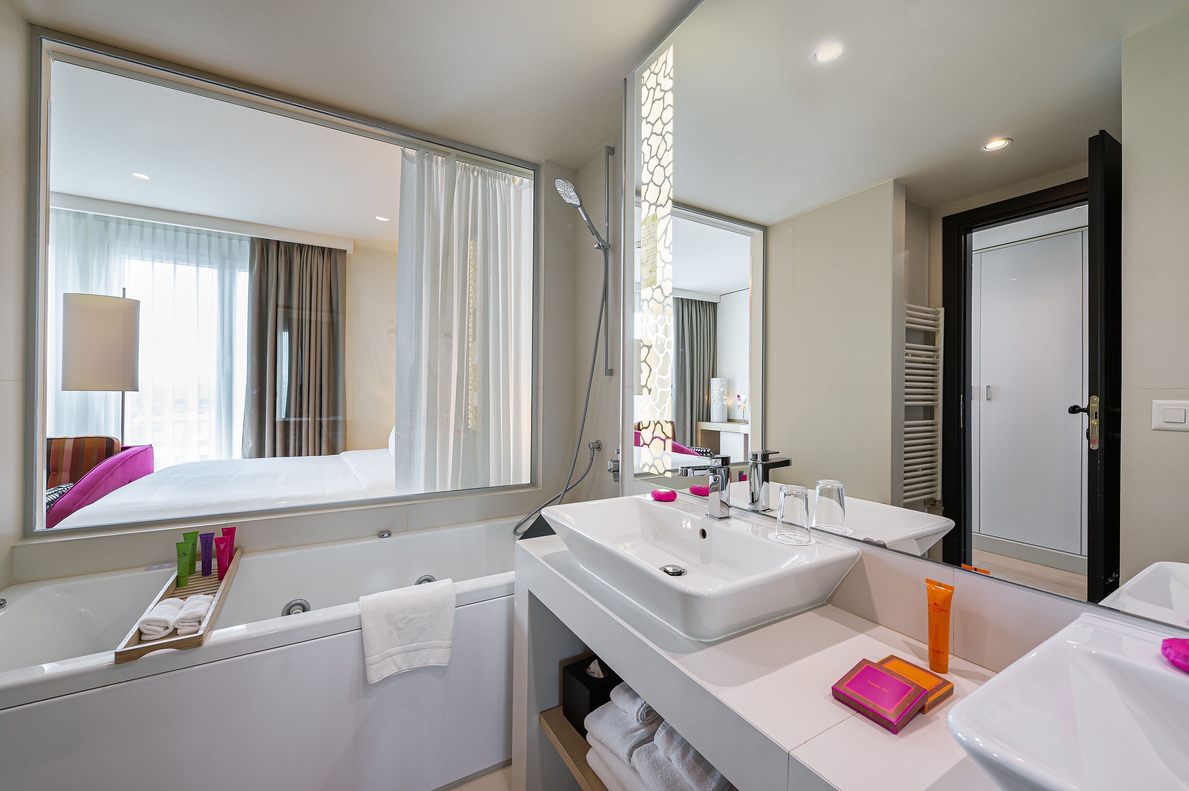 Un bagno moderno con un ampio specchio, due lavandini, una vasca e una doccia.