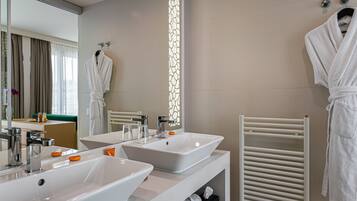 A modern bathroom with two sinks, a towel rack, and a mirror.