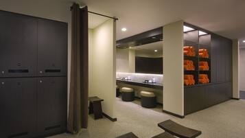 A modern bathroom with a large mirror, a vanity with a sink, and a towel rack with folded towels.
