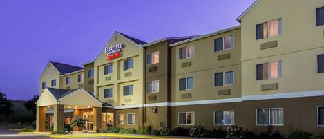 Un hotel de varios pisos con una entrada destacada y señalización de Fairfield Inn & Suites.