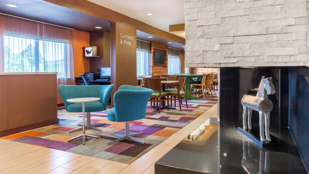 A hotel lobby with a reception desk, seating area, and a fireplace. - Fairfield Inn & Suites Sioux Falls (Sioux Falls)