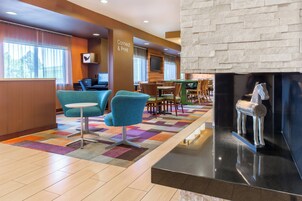 A hotel lobby with a reception desk, seating area, and a fireplace.