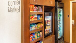 A corner market with shelves stocked with snacks and a refrigerated display. - Fairfield Inn & Suites Sioux Falls (Sioux Falls)