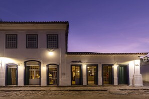 Un edificio con varias puertas y ventanas, algunas con paneles de vidrio, y un letrero sobre una puerta que dice "RECEPTION".